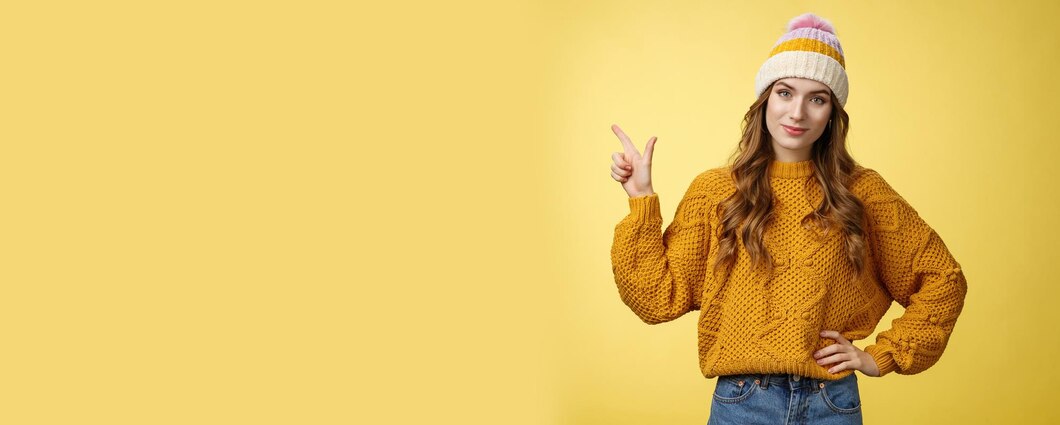 Model in yellow sweater and knit beanie pointing to banner text area
